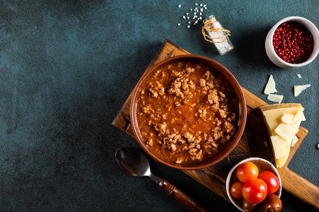 Klasyczny włoski sos boloński z dodatkami na niebieskim tle. Widok z góry na sos boloński. kulinarne tło z miejscem na tekst. Makaron bolognese. włoska lasagne