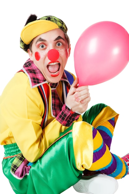 Zdjęcie klaun siots z balonem w dłoni na białym tle na białym tle