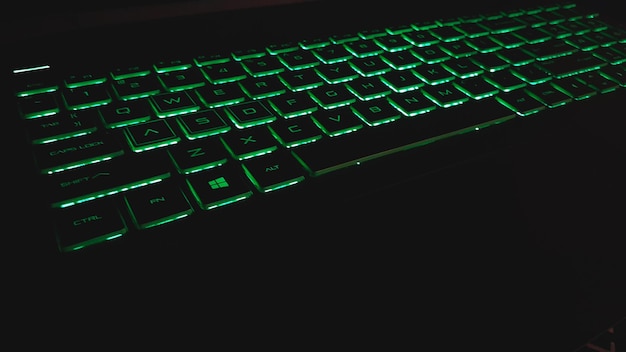 Klawiatura laptopa typu Qwerty z zielonym światłem Nowoczesna technologia tła i tapety