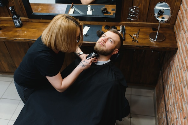 Klient podczas golenia brody w salonie fryzjerskim