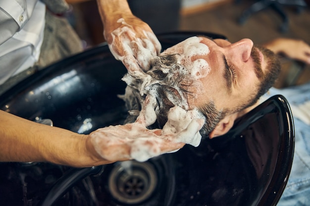 Zdjęcie klient umyty i umyty szamponem w dobrze wyposażonym salonie fryzjerskim