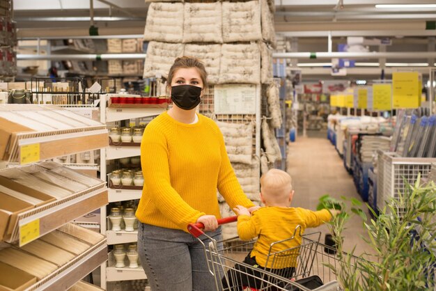 Zdjęcie klient z dzieckiem w jednorazowej masce wybiera elementy wystroju domu w sklepie nowy normalny