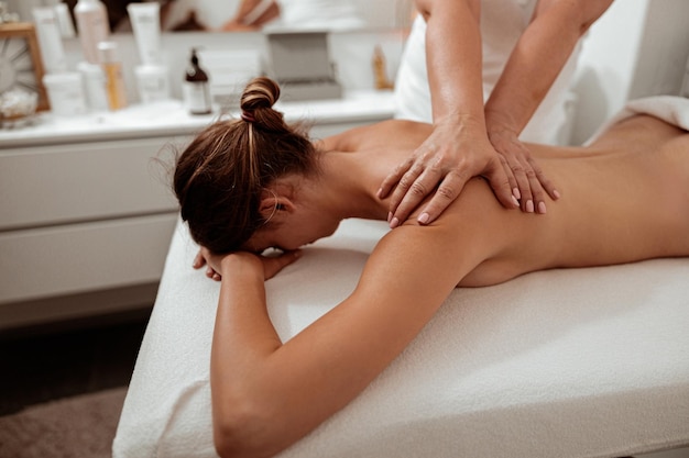 Zdjęcie klientka otrzymująca masaż terapeutyczny w salonie spa