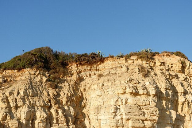 Klif skały na tle błękitnego nieba w słoneczny dzień w regionie Lagos Algarve Portugalia