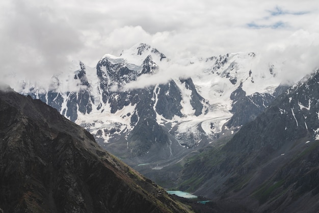 Klimatyczny alpejski krajobraz z ogromnym wiszącym lodowcem na gigantycznej górze.