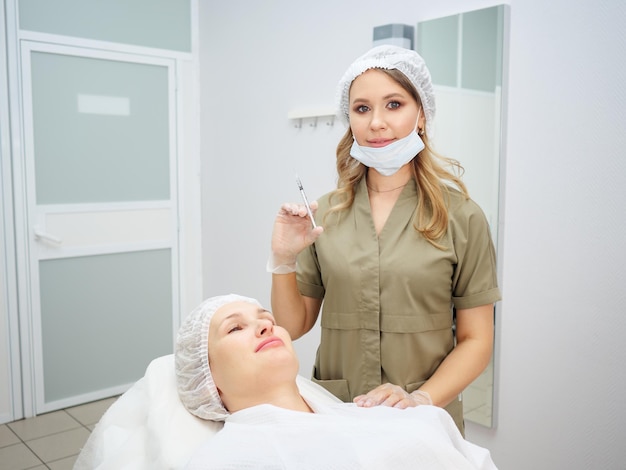 Klinika kosmetologiczna lekarka przygotowuje się do wstrzyknięcia w celu zaostrzenia wypełniacza utrzymującego kontur twarzy kwasem hialuronowym
