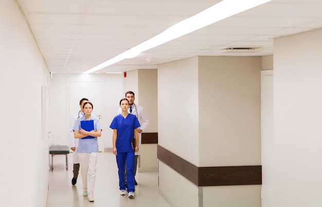 klinika, zawód, ludzie, opieka zdrowotna i koncepcja medycyny - grupa lekarzy lub lekarzy idących korytarzem szpitala