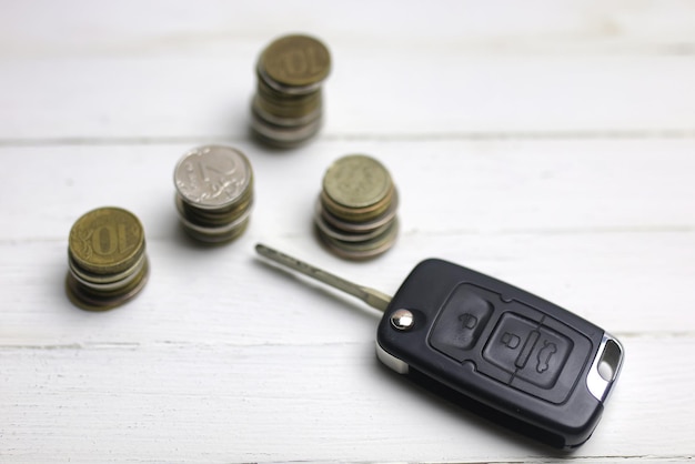 Klucz samochodowy i moneta na tle