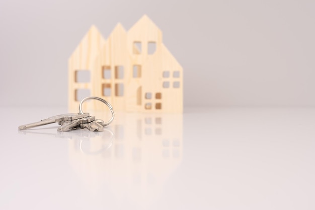 Zdjęcie klucze do domów na tle drewnianych modeli domów selektywne skupienie inwestycji kredyt hipoteczny realny