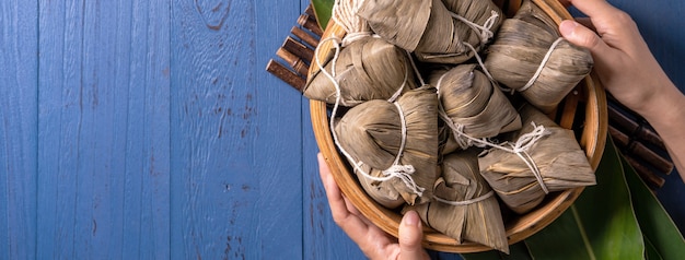 Knedle ryżowe Zongzi ze składnikami widok z góry na chiński tradycyjny festiwal Dragon Boat (Duanwu Festival) na niebieskim tle drewnianego stołu