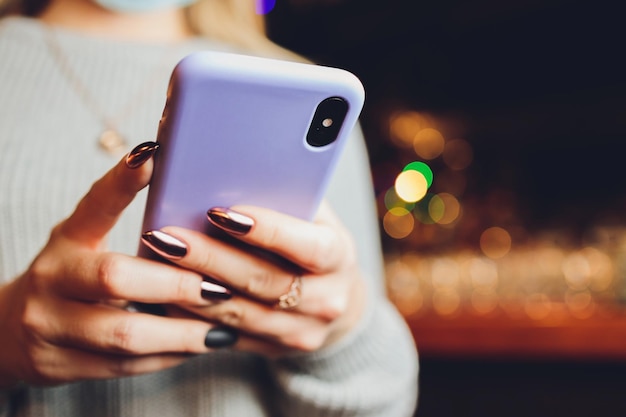 Kobieca dłoń trzymająca fioletowy telefon w przezroczystej silikonowej obudowie na białym tle Przezroczysta obudowa telefonu makieta widok z tyłu