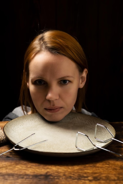 Kobieca głowa na talerzu na ciemnym tle Strach przed dietą apatii koncepcji
