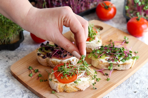 Kobieca Ręka Dodająca Microgreens Do Tostów Lub Bruschetty Zdrowe Wegańskie Jedzenie I Dieta