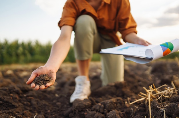 Zdjęcie kobieca ręka doświadczonego rolnika zbiera glebę i sprawdza stan gleby przed wyhodowaniem nasion warzyw
