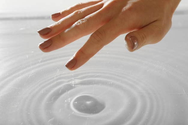 Kobieca ręka dotykająca powierzchni wody
