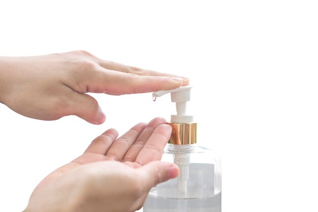Kobieca ręka popychająca butelkę z pompką środka dezynfekującego do czyszczenia na na białym tle