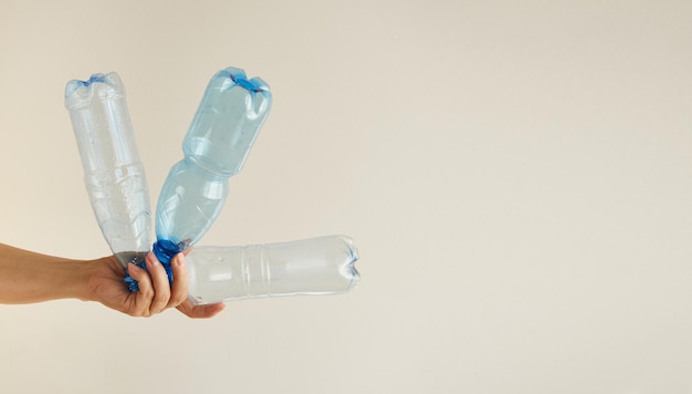Zdjęcie kobieca ręka trzyma kilka pustych plastikowych butelek