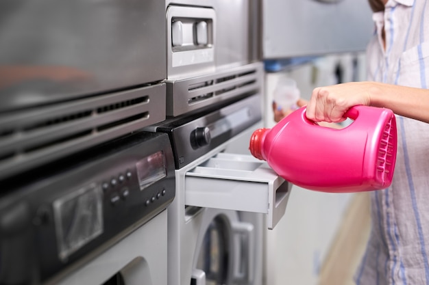 Kobieca Ręka Wlewa Tłusty Detergent Z Różowej Butelki Do Komory Pralki W Pralni