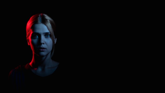 Kobieca sylwetka portret Wsparcie psychologiczne Przestraszona kobieta w blasku neonów patrząc na kamerę odizolowaną na czarnym radzeniu sobie z przestrzenią Przemoc domowa Nadużycie Relacja Tło reklamowe
