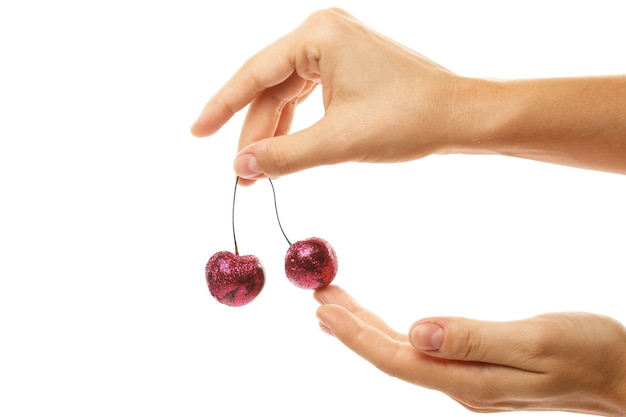 Kobiece dłonie i wiśniowe jagody pokryte kolorowymi błyskami