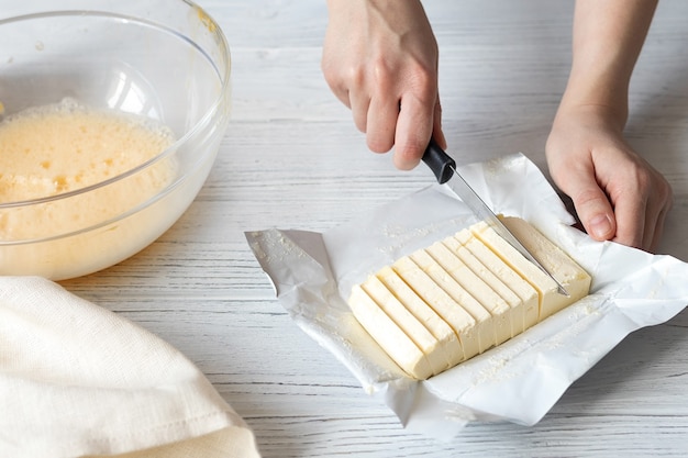 Zdjęcie kobiece dłonie krojenie masła do domowych wypieków