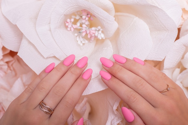 Kobiece dłonie ze ślubnymi paznokciami manicure różowy lakier hybrydowy