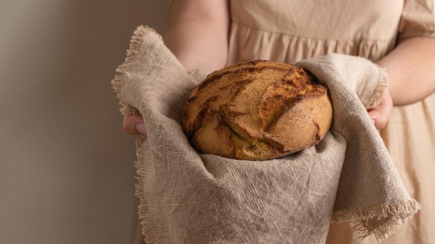 Zdjęcie kobiece dłonie ze świeżym tradycyjnym portugalskim chlebem kukurydzianym
