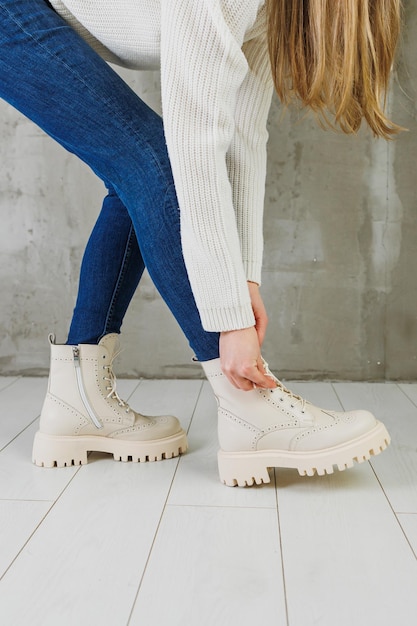 Kobiece nogi w dżinsach i białych skórzanych butach ze skóry naturalnej Kolekcja damskich wiosennych nowoczesnych butów
