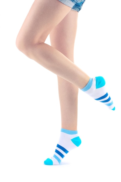 Zdjęcie kobiece nogi w paskowych skarpetkach izolowane na białym