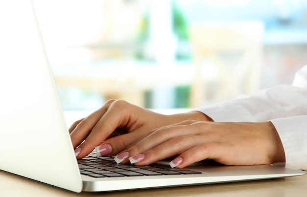 Kobiece ręce piszące na laptopie z bliska