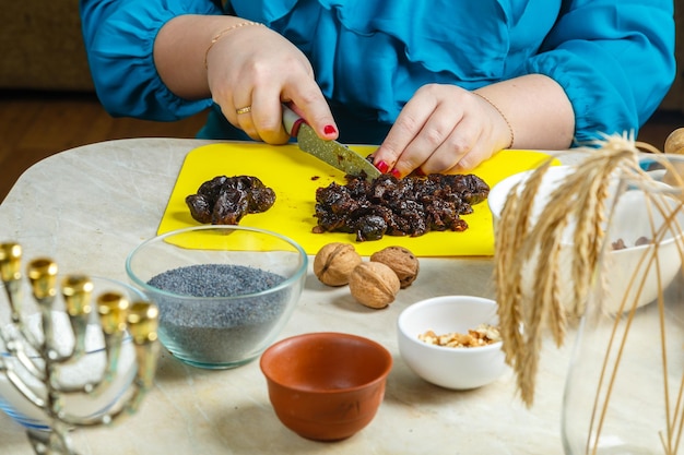 Zdjęcie kobiece ręce robią tradycyjne dla żydów nadzienie ze śliwek do makowych ciasteczek gomentashi