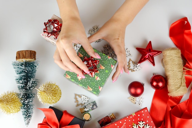Zdjęcie kobiece ręce zbliżenie pakowanie prezentów świątecznych ręcznie robione dekoracje świąteczne na stole