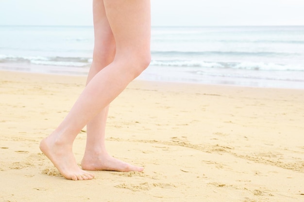 Kobiece stopy na plaży Bosonoga kobieta idzie wzdłuż piasku w kierunku morza