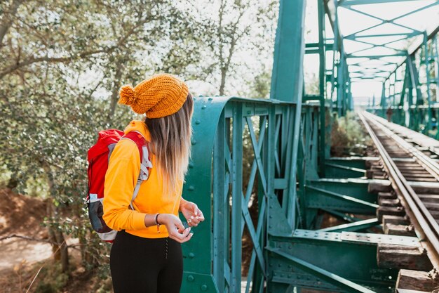 Kobieta badająca szlaki i stary żelazny most kolejowy