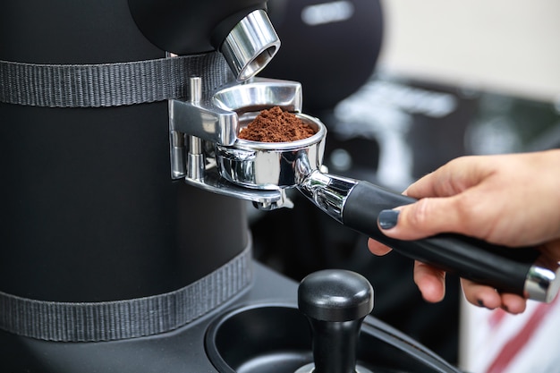 Kobieta-barista miele coffblackdayee fasolę do kolby
