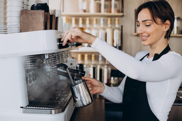 Zdjęcie kobieta barista w kawiarni przygotowuje kawę