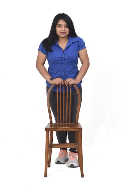 Kobieta bawi się krzesłem na białym tle