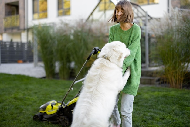 Kobieta bawi się z psem na podwórku podczas prac w ogrodzie