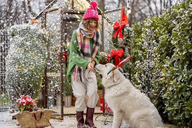 Kobieta bawi się z psem podczas ferii zimowych na podwórku