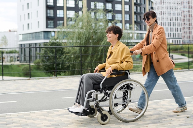 Kobieta bawiąca się ze swoją niepełnosprawną przyjaciółką podczas spaceru po mieście