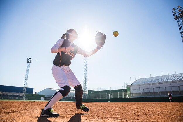 Kobieta bejsbolista łapie piłkę podczas gry w baseball