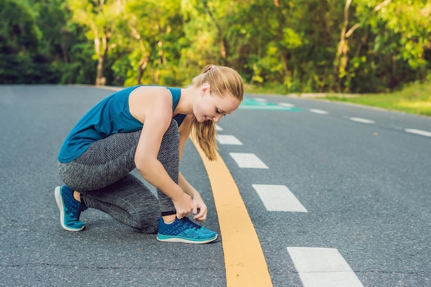 Kobieta Biegacz Wiązanie Jej Buty Przygotowujące Do Biegania Na Zewnątrz. Młoda Dziewczyna Biegacz Przygotowuje Się Do Treningu. Sportowy Styl życia