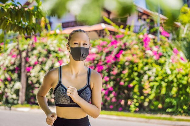 Kobieta biegająca w masce medycznej biega w parku pandemia koronawirusa Covid sport aktywne życie