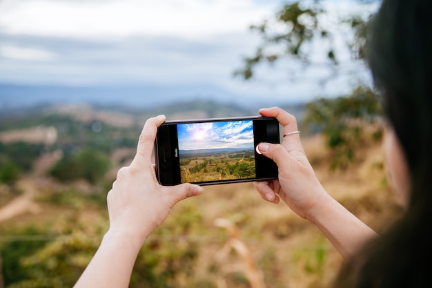 Kobieta bierze fotografię z jej telefonem komórkowym