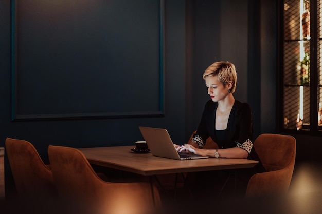 Kobieta biznesmena siedząca w kawiarni, skupiająca się na pracy na laptopie i uczestnicząca w spotkaniach internetowych Selektywne skupienie Zdjęcie wysokiej jakości