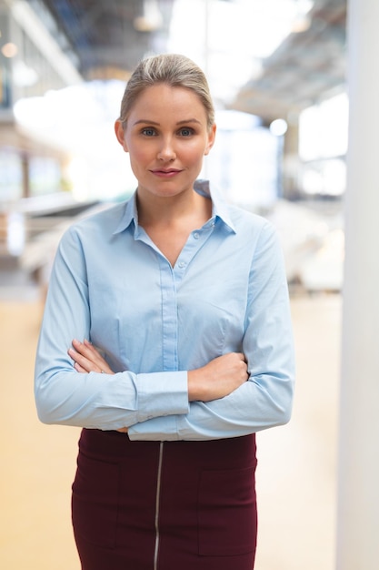 Zdjęcie kobieta biznesmena stojąca z skrzyżowanymi ramionami na korytarzu w biurze