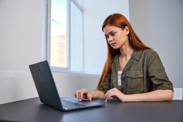 Kobieta biznesowa używająca laptopa siedząc na stole