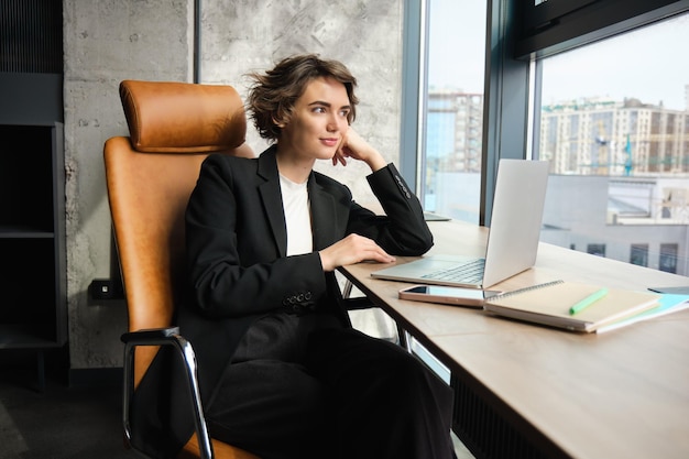 Zdjęcie kobieta biznesowa używająca laptopa siedząc w kawiarni