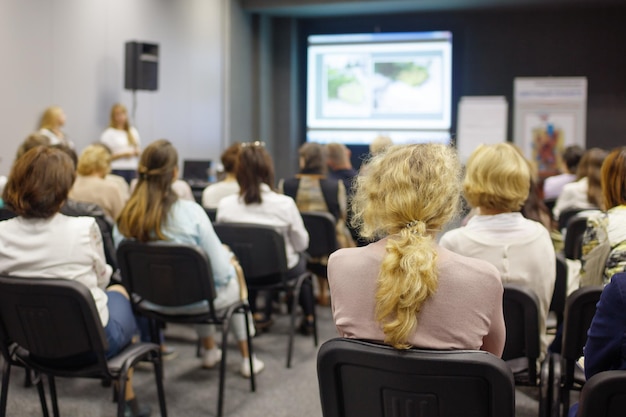 Kobieta biznesu i ludzie słuchający na konferencji Obraz poziomy