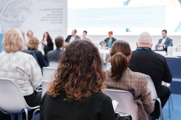 Kobieta biznesu i ludzie słuchający na konferencji Obraz poziomy